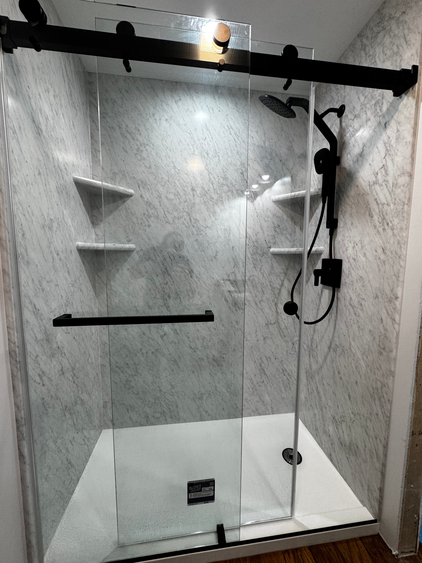 Carrara marble walk-in shower with matte black hardware